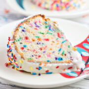 thick slice of white funfetti bundt cake on a dessert plate.