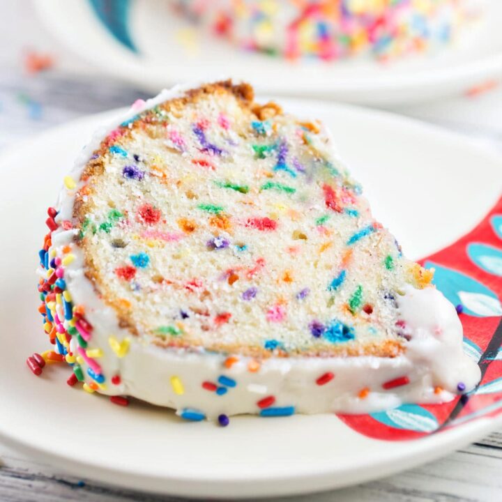 thick slice of white funfetti bundt cake on a dessert plate.