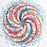 spiral swirled red white and blue bundt cake covered with sprinkles