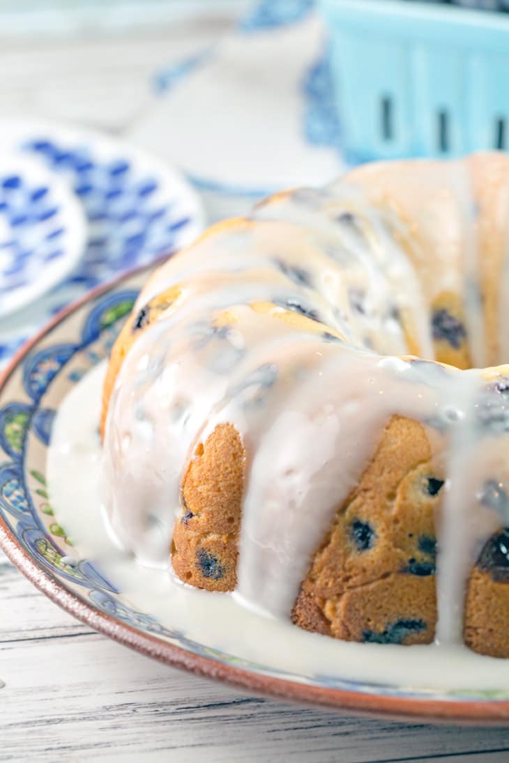 side view of a bundt cake with a pool of lemon glaze running over the sides