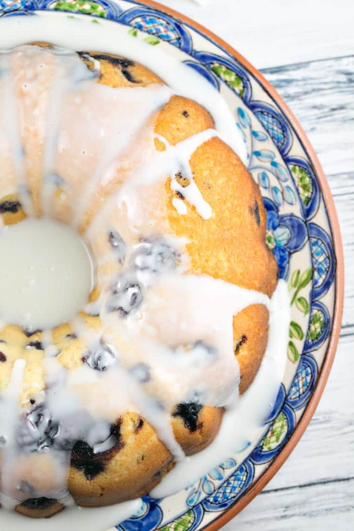 bundt cake full of blueberries and covered with lemon glaze