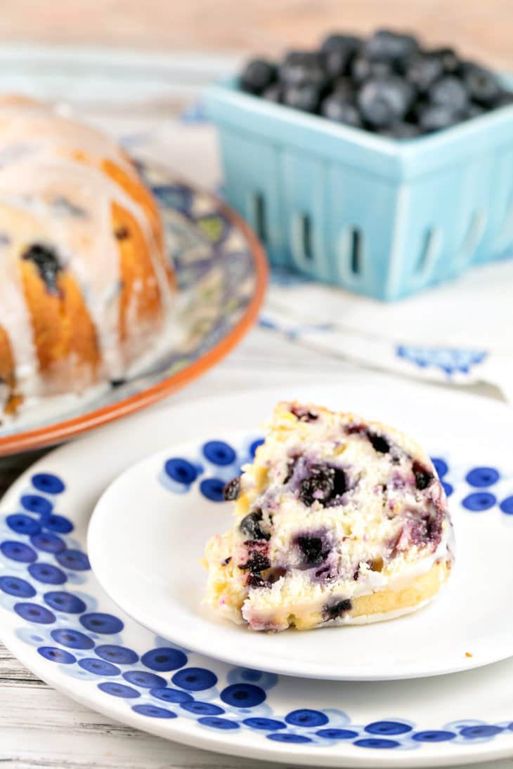 slice of bundt cake on a decorative blueberry cake plate