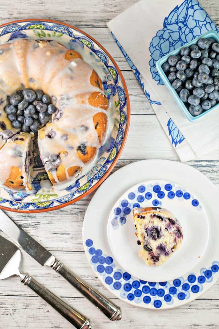 slice of lemon blueberry bundt cake next to the rest of the cake