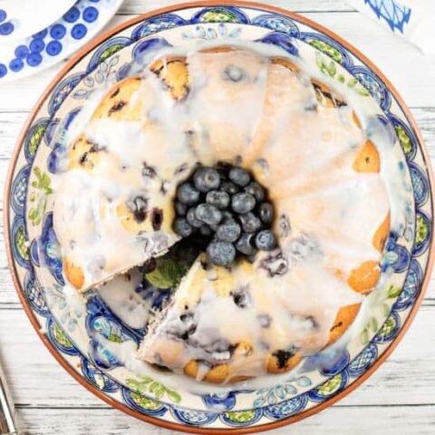 bundt cake covered in lemon glaze with blueberries in the center