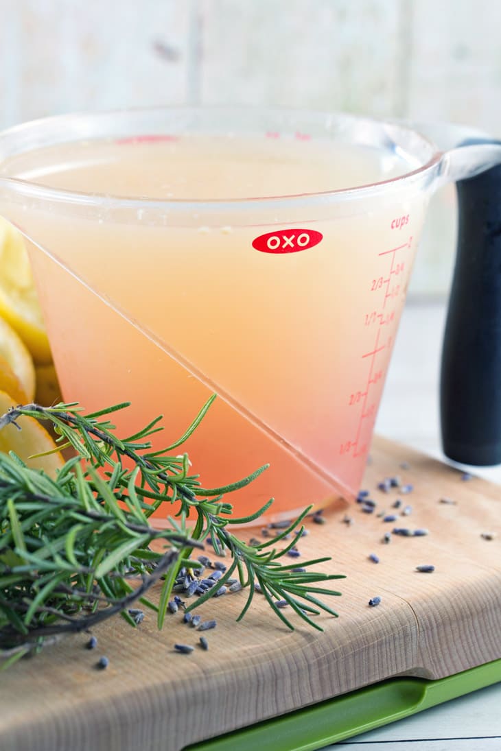 measuring cup filled with simple syrup infused with rosemary and lavender