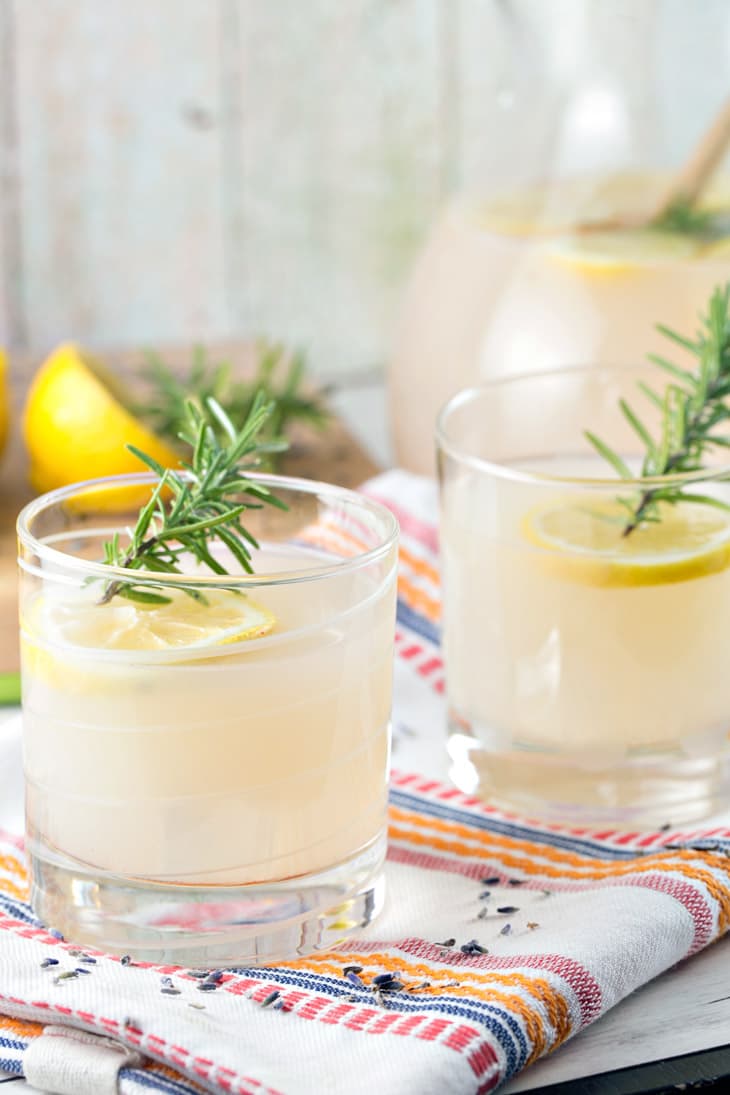 two lowball glasses filled with lemonade and a sprig of rosemary