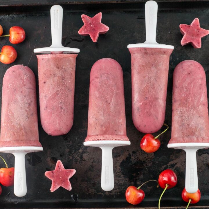 watermelon cherry yogurt popsicles on a dark background