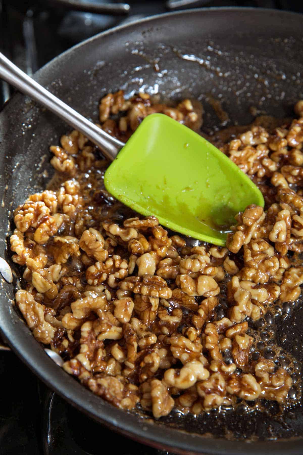 picture of walnuts in a frying pan covered with maple syrup.