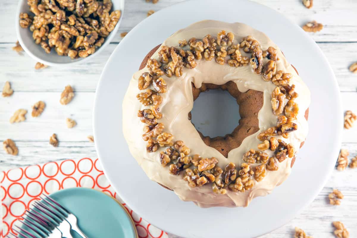 overhead photo of a bundt cake covered in maple frosting and candied walnuts
