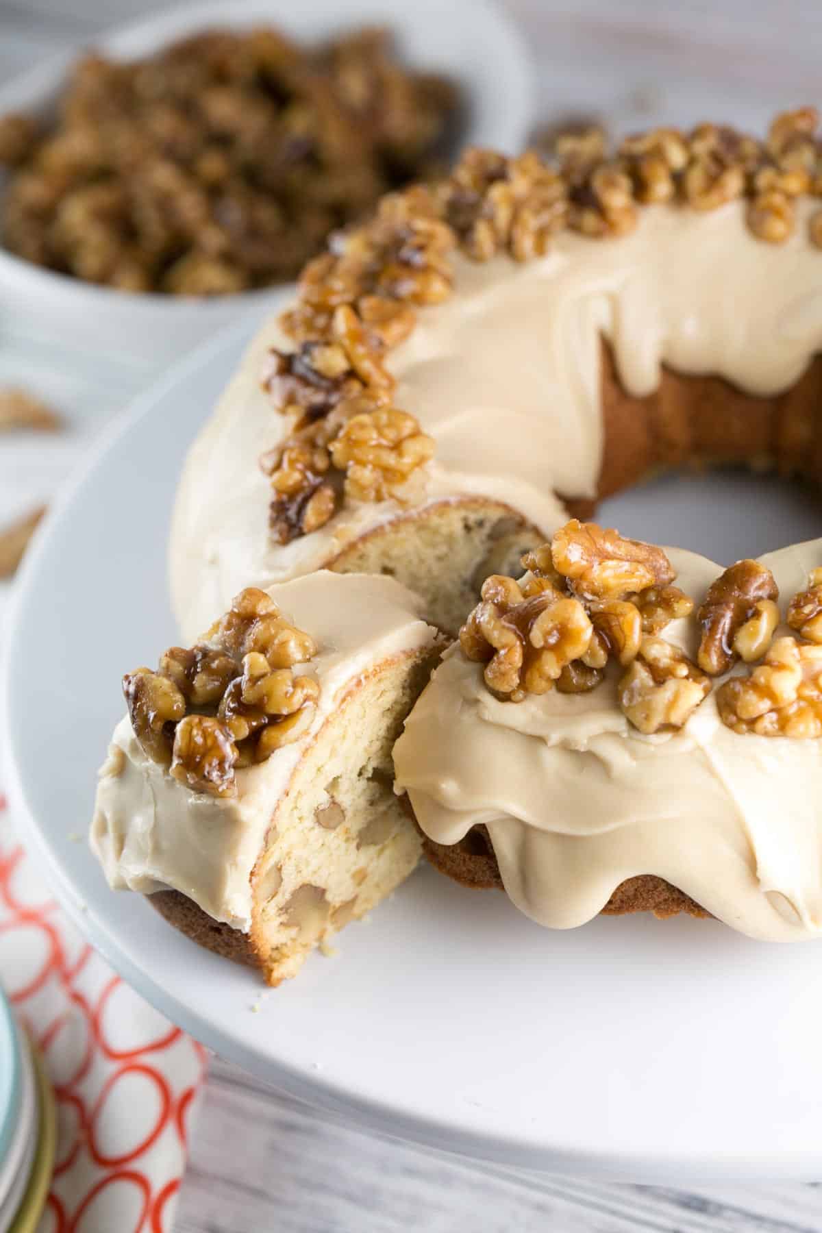 closeup view of a maple walnut bundt cake with one slice pulled out