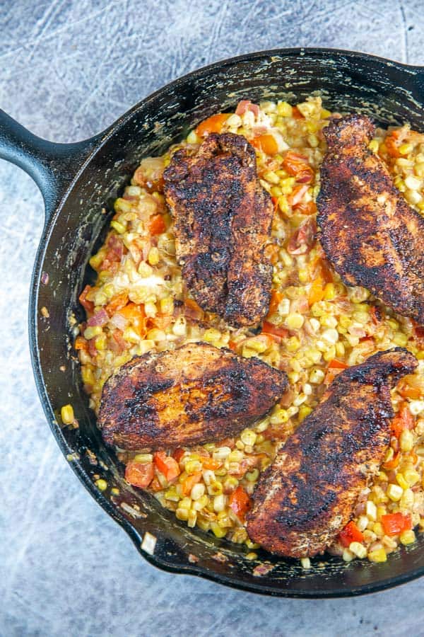 seared chicken with spices on a creamy corn and jalapeno mixture