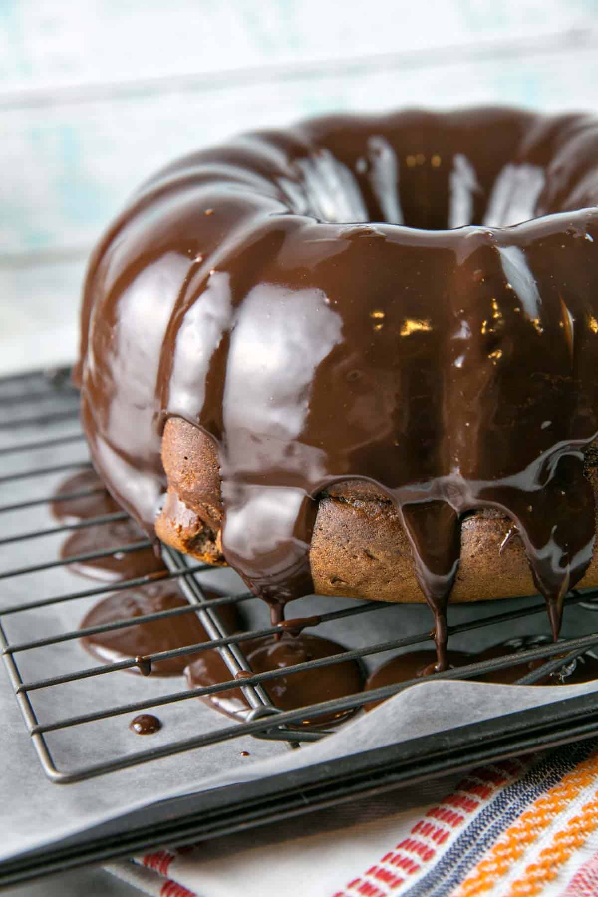 pumpkin bundt cake covered in chocolate glaze dripping off the side.