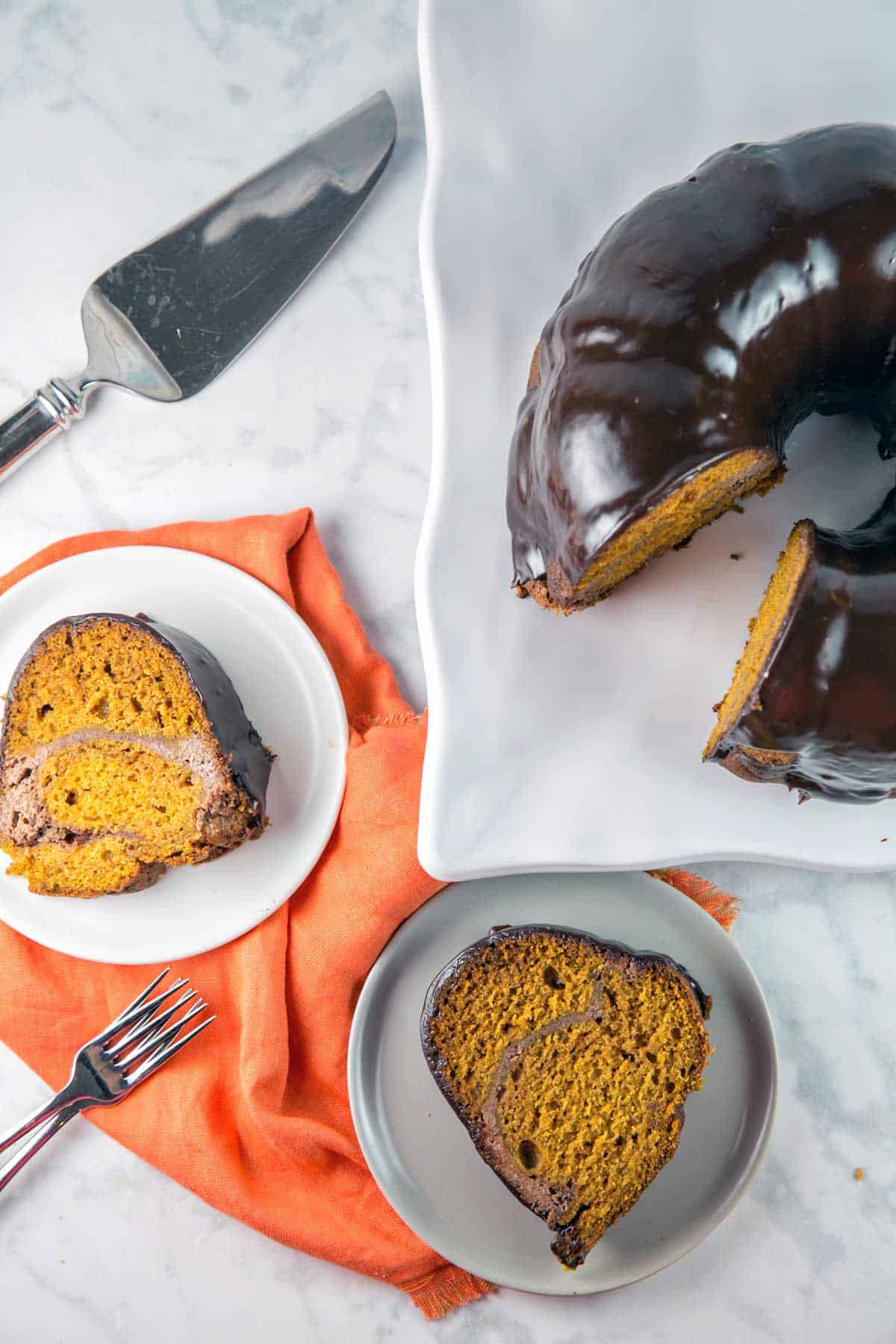 two slices of pumpkin bundt cake next to a chocolate covered cake