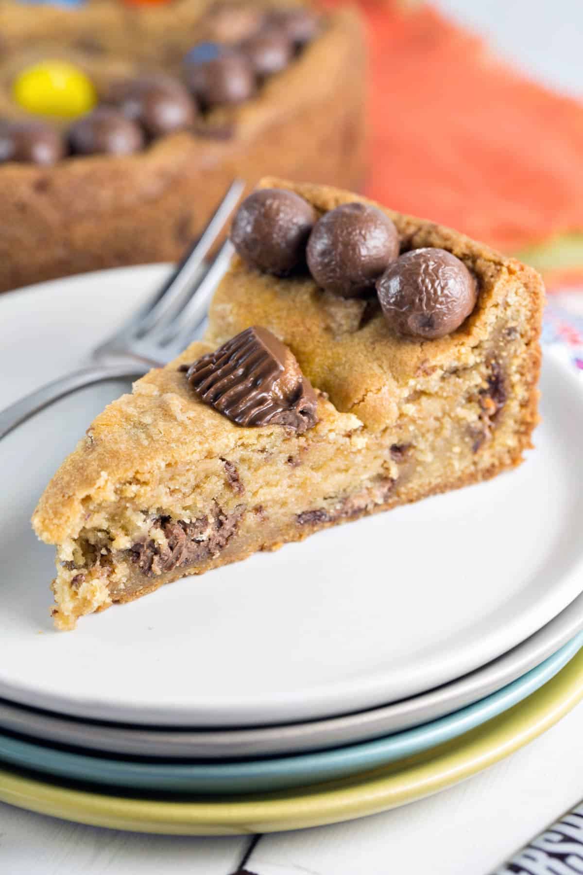 side view of a slice of candy cookie cake showing the soft inside filled with candy.