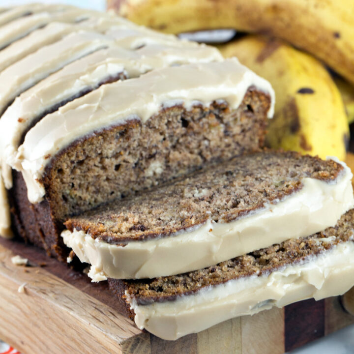 two slices cut from a loaf of banana bread covered with a thick maple glaze