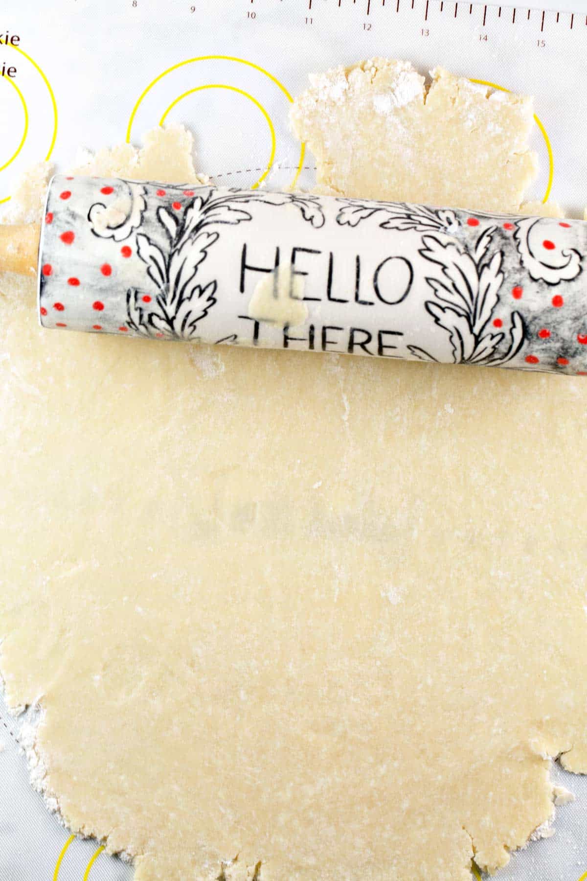 pie crust dough rolled out in a flat sheet with a rolling pin with the words "hello there".