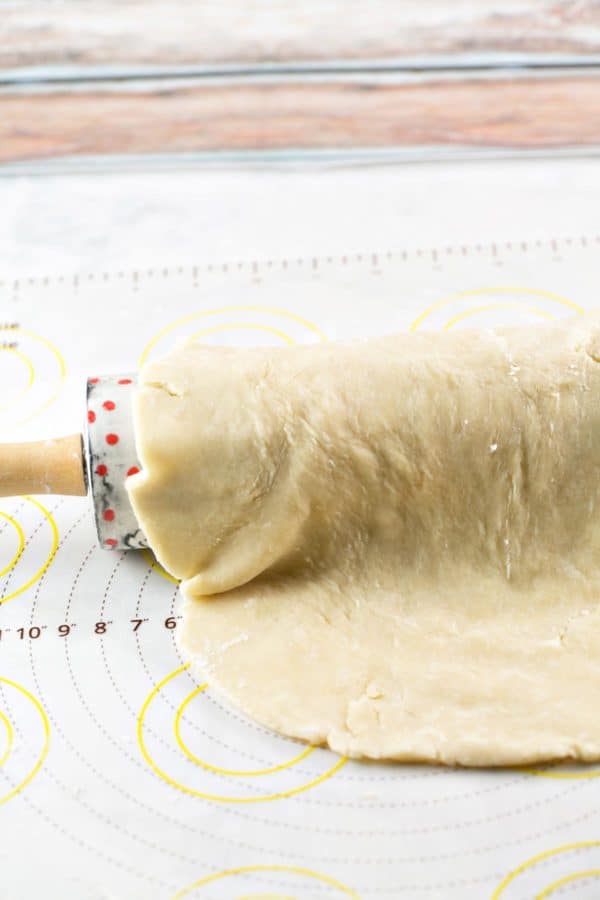 sheet of pie crust dough draped over a decorative rolling pin