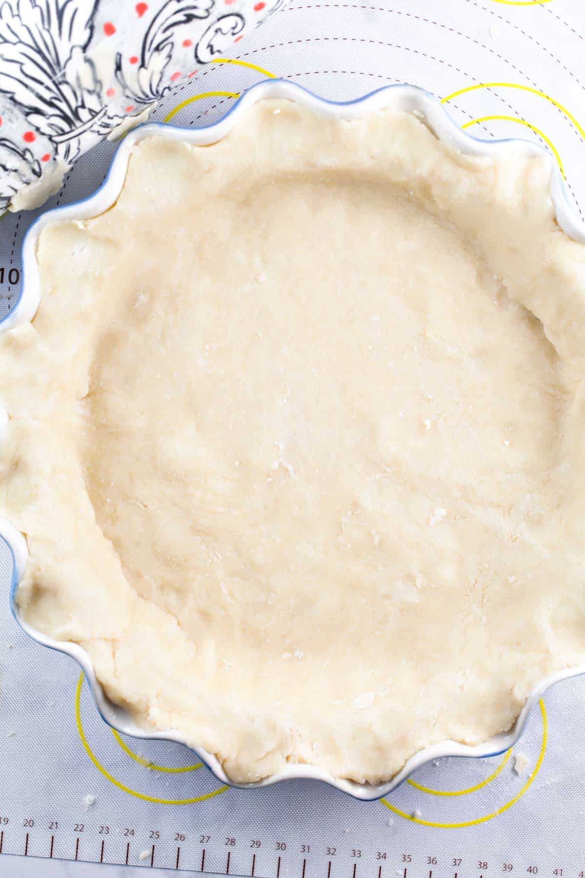 overhead view of an unbaked pie crust in a fluted pie plate.