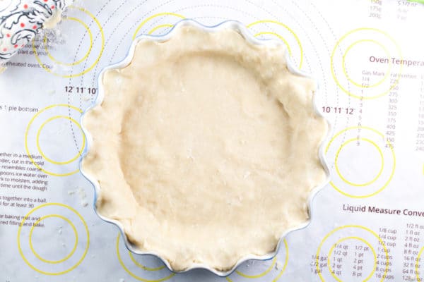 overhead view of pie crust pressed into a blue fluted pie dish