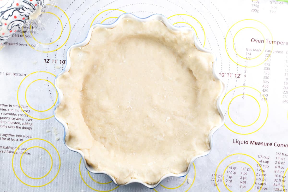 overhead view of pie crust pressed into a blue fluted pie dish.