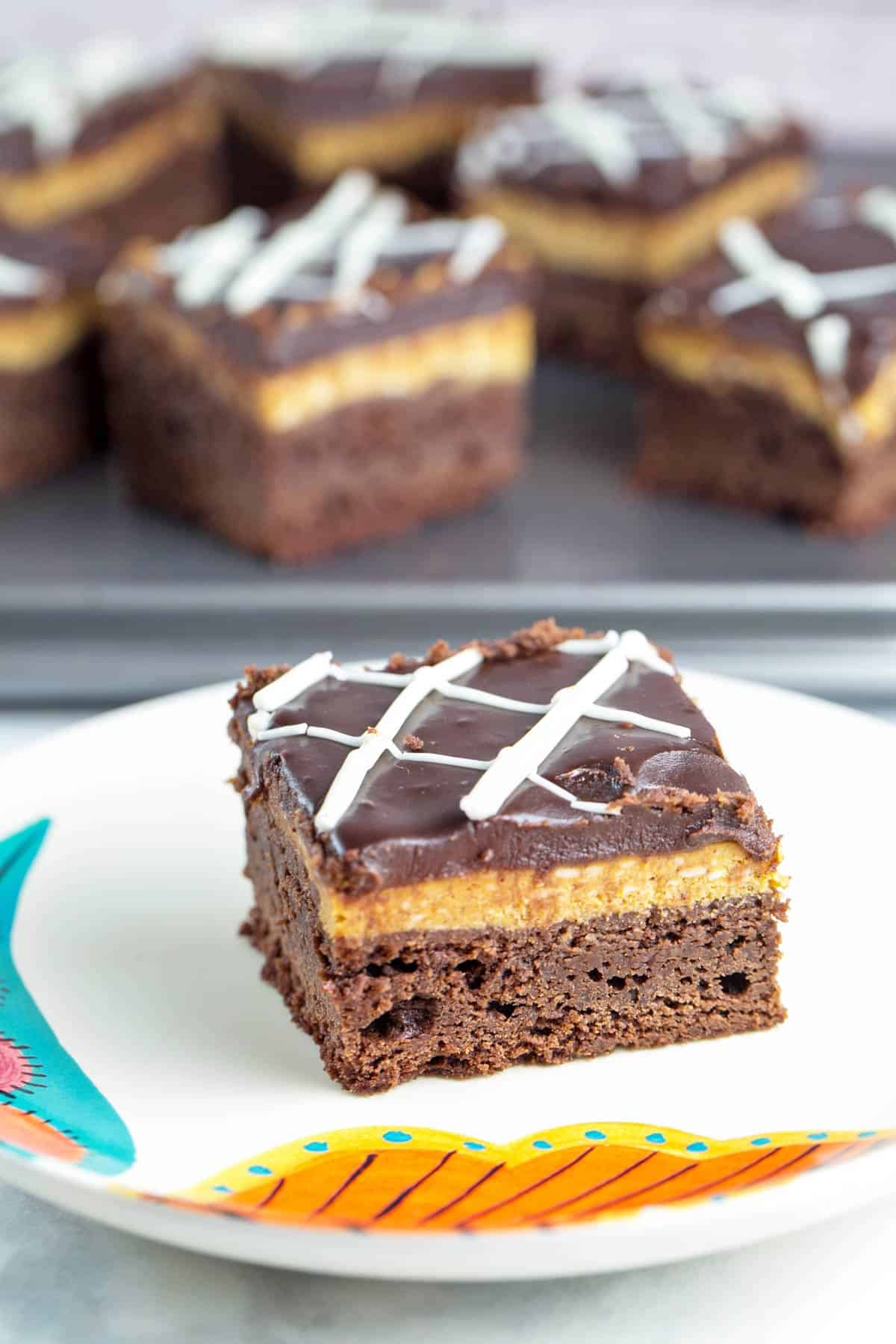 pumpkin cheesecake brownies on a white plate.