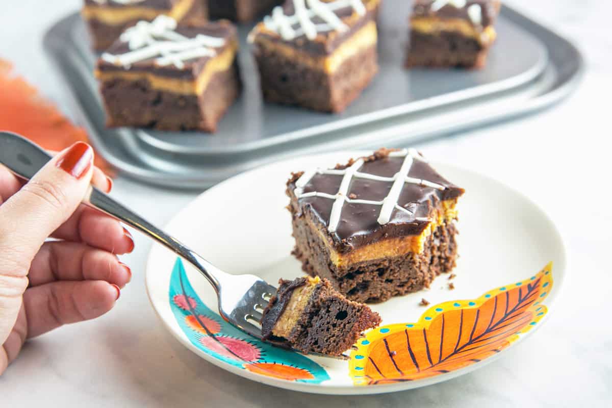 overhead angle of pumpkin cheesecake brownie with two forkfuls removed.