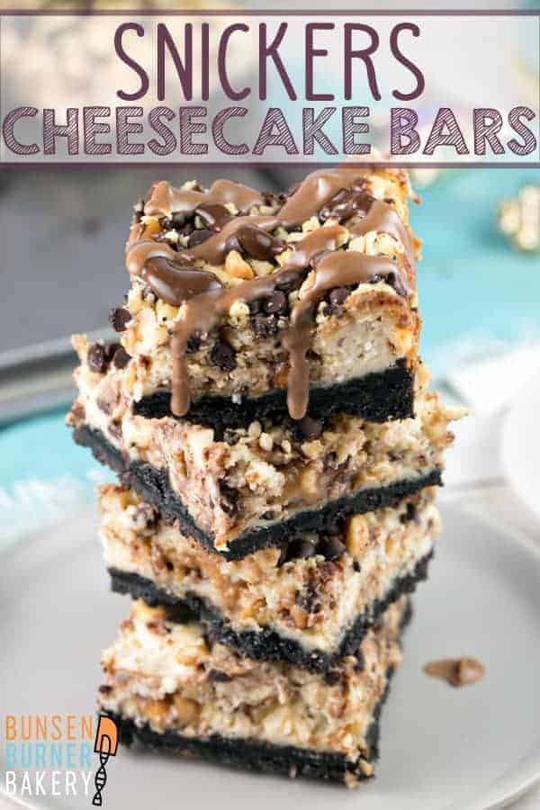 Snickers Cheesecake Bars: Handheld cheesecake bars full of chopped Snickers, a crunchy chocolate and peanut topping, and a drizzle of melted chocolate and caramel. #bunsenburnerbakery #cheesecake #Snickers #cheesecakebars