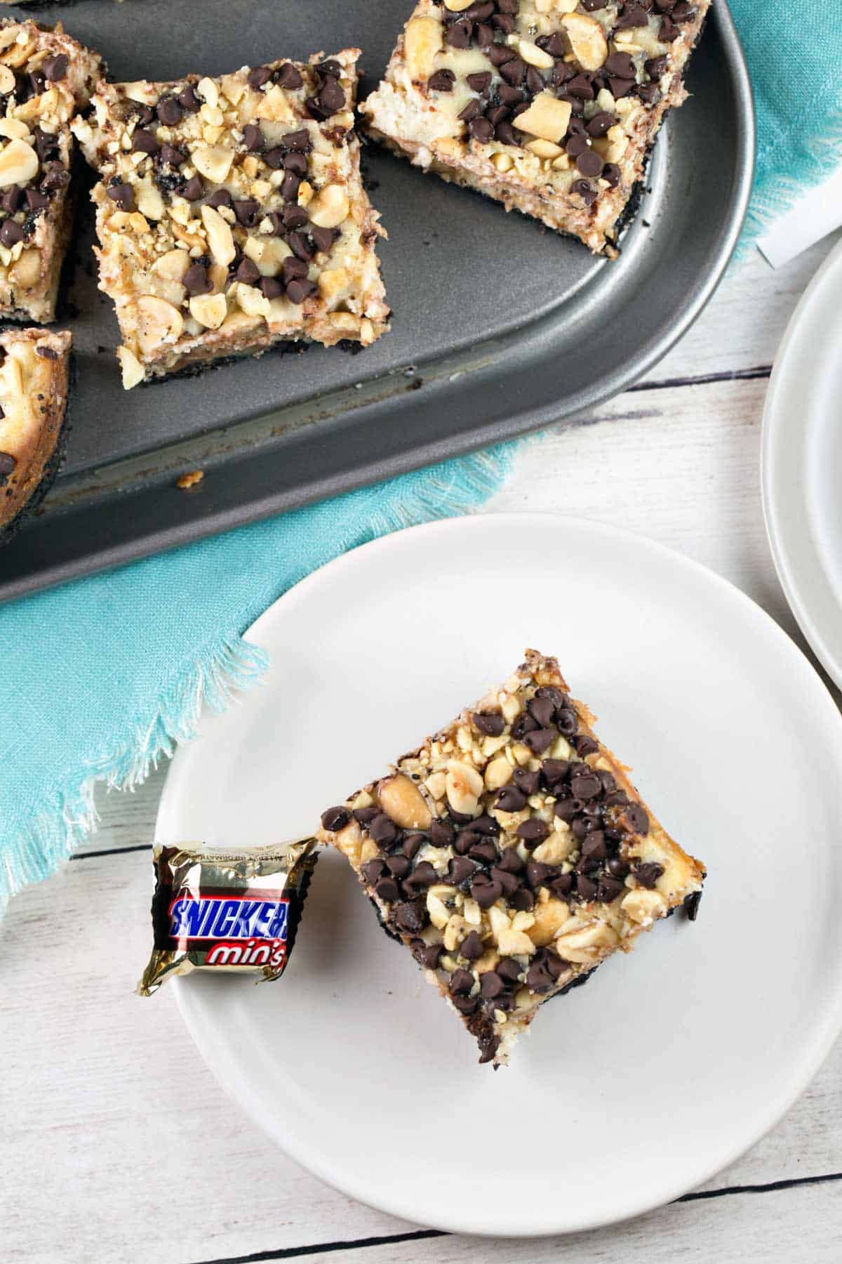 handheld snickers cheesecake bars with an oreo cookie crust