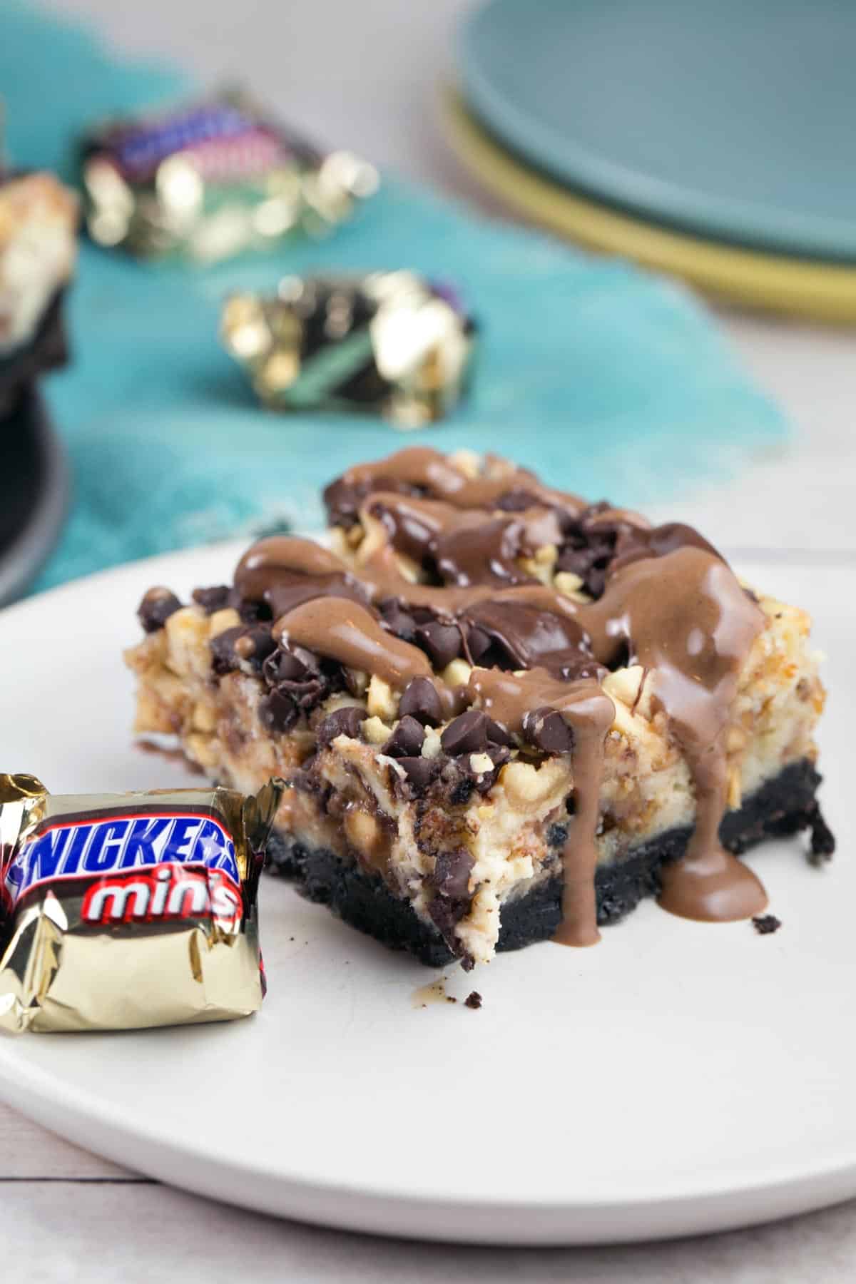 snickers cheesecake bar drizzled with chocolate and caramel sauce.