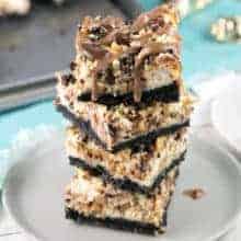 stack of snickers cheesecake bars with an oreo cookie crust