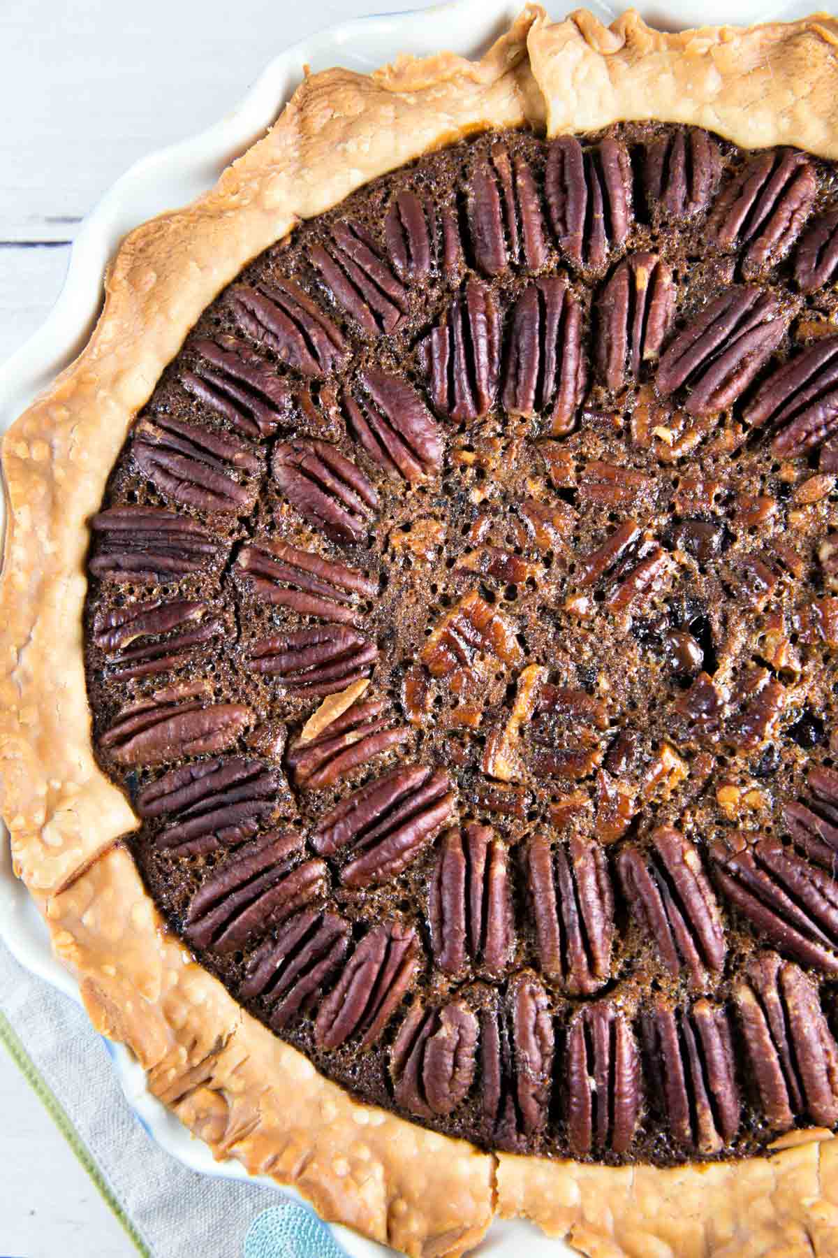 overhead closeup of a chocolate bourbon pecan pie with pecans arranged in concentric circles.