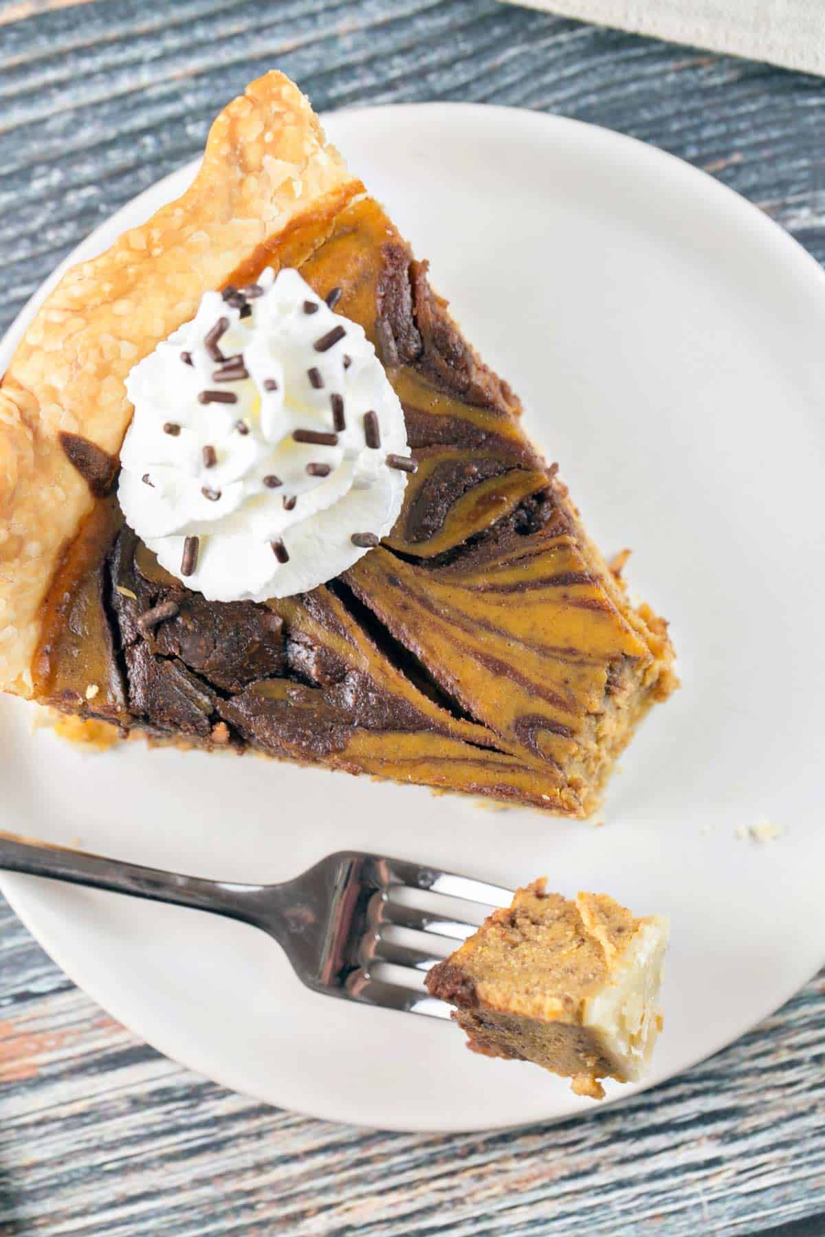 overhead view of a slice of nutella swirled pumpkin pie with one forkful removed