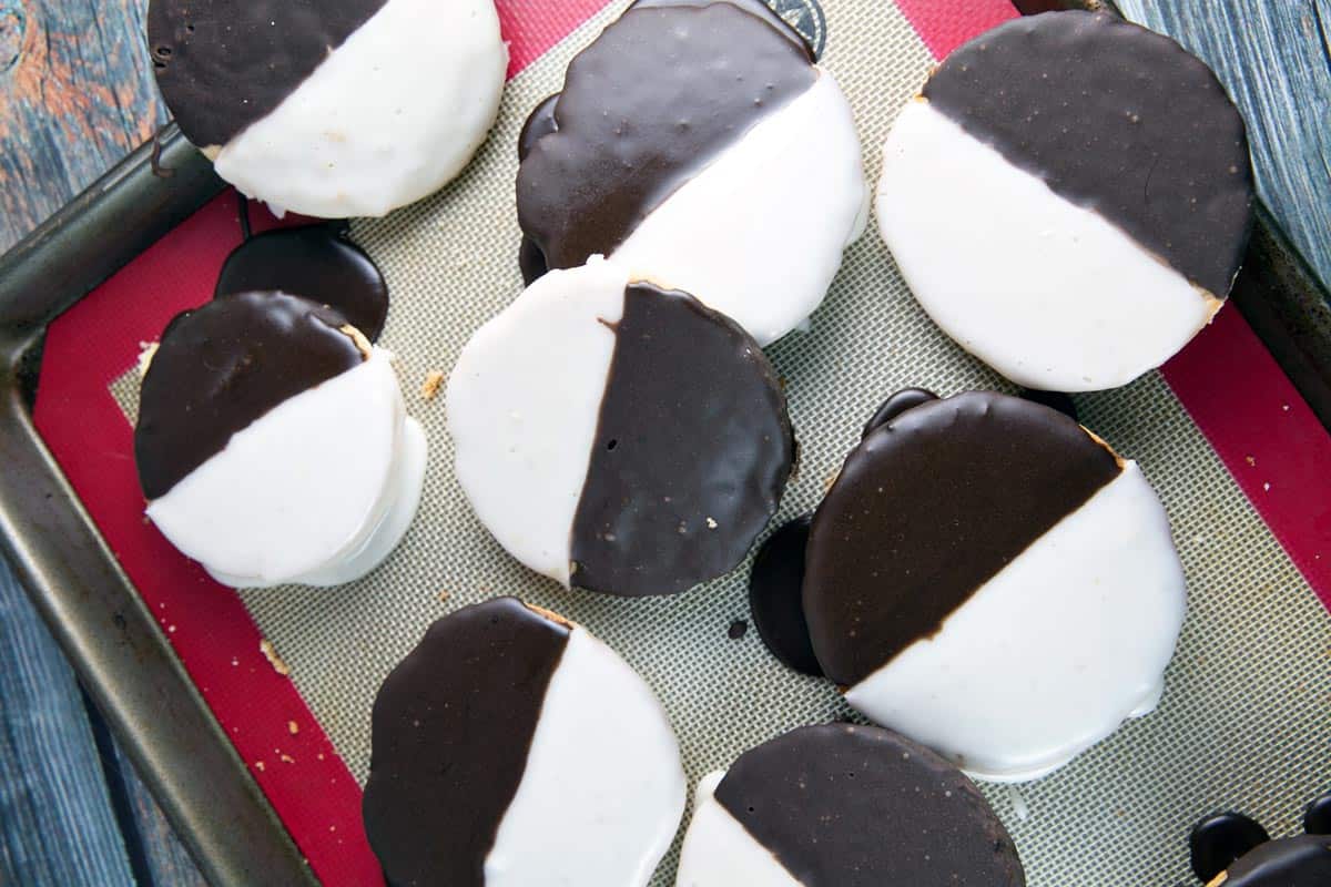 eight black and white cookies on a silpat baking mat