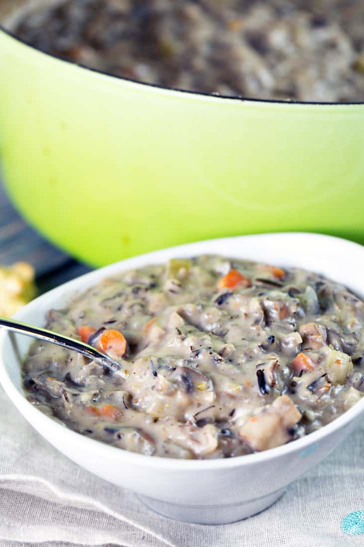 bowl filled with soup in front of a green dutch oven.