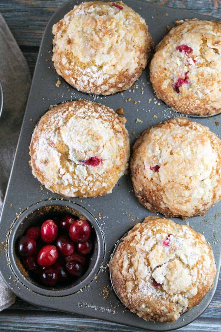 muffin tin filled with freshly baked cranberry orange muffins.