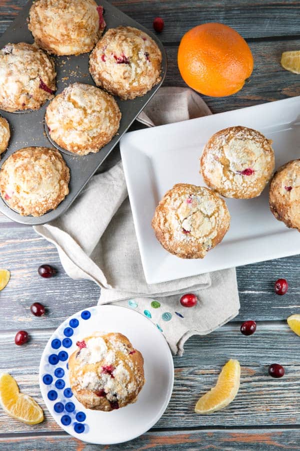 streusel topped muffins surrounded by orange slices and whole cranberries.