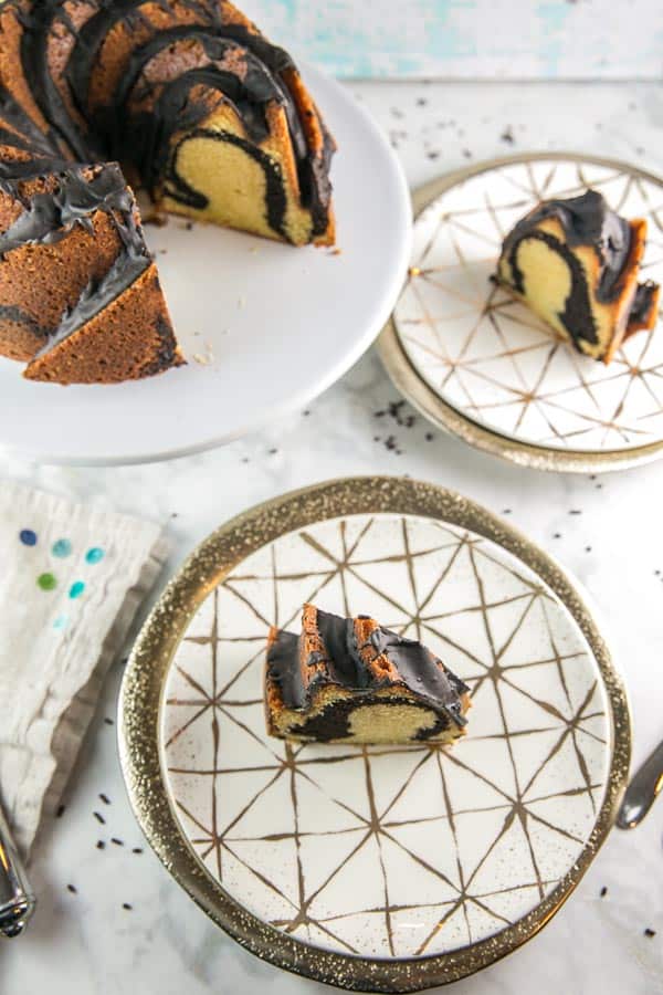 overhead view of two slices of chocolate and vanilla swirled bundt cake on decorative plates.