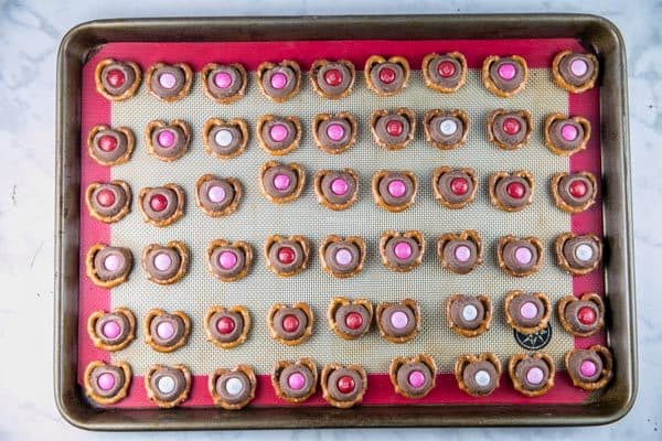 m&m pretzel kisses lined up in neat rows on a sheet pan