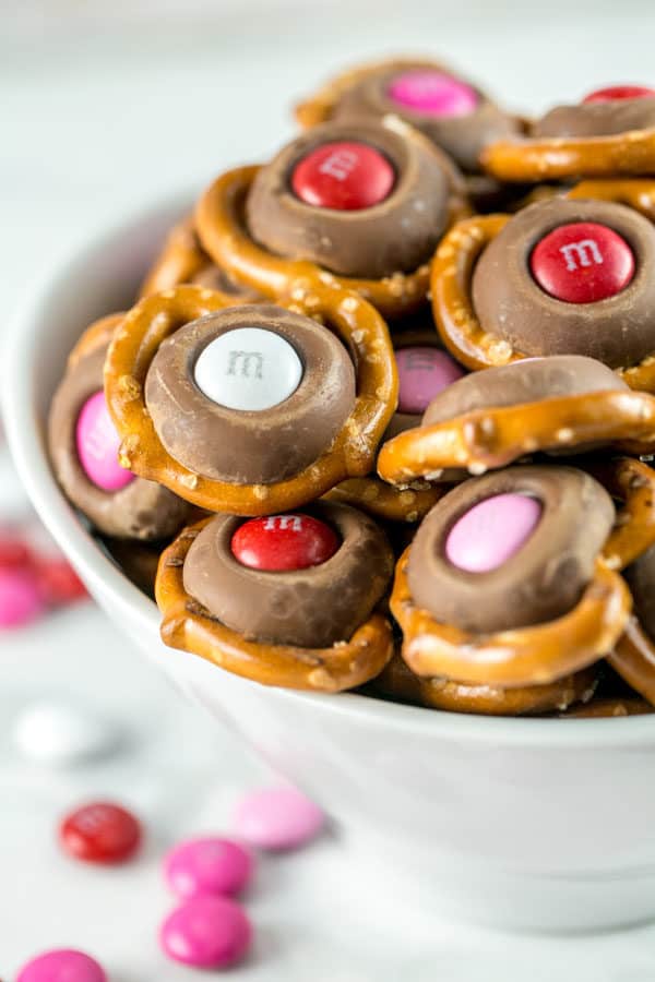 m&m pretzel kisses with valentine's colored m&ms in a white bowl