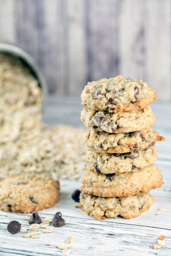 a vertical stack of oatmeal chocolate chip cookies with rolled oats in the background.