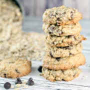 stack of oatmeal chocolate chip cookies next to a pile of rolled oats.