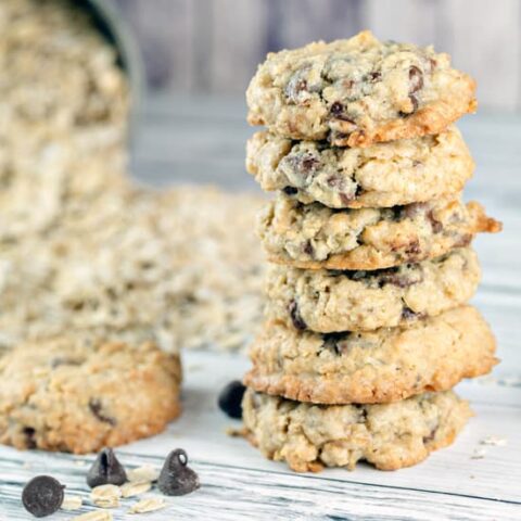 stack of oatmeal chocolate chip cookies next to a pile of rolled oats.