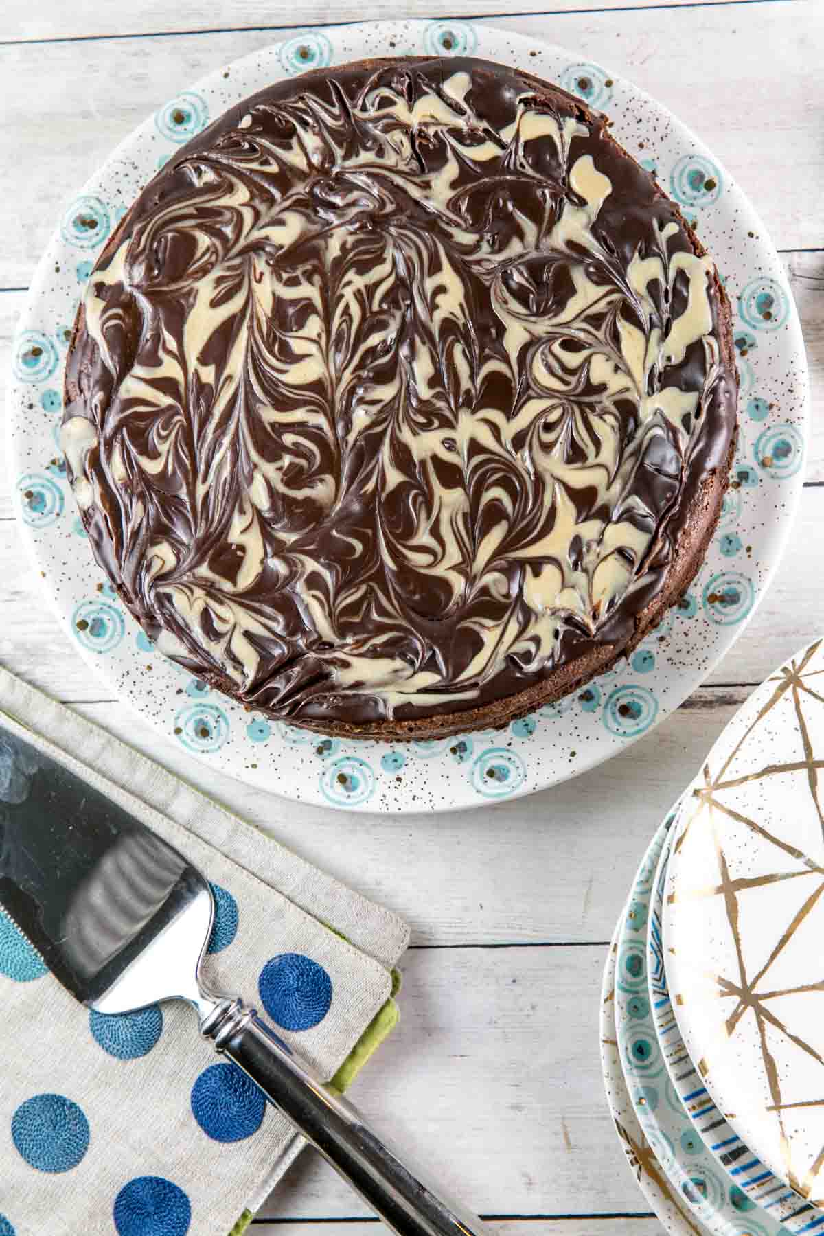 uncut flourless chocolate cake covered with swirls of tahini