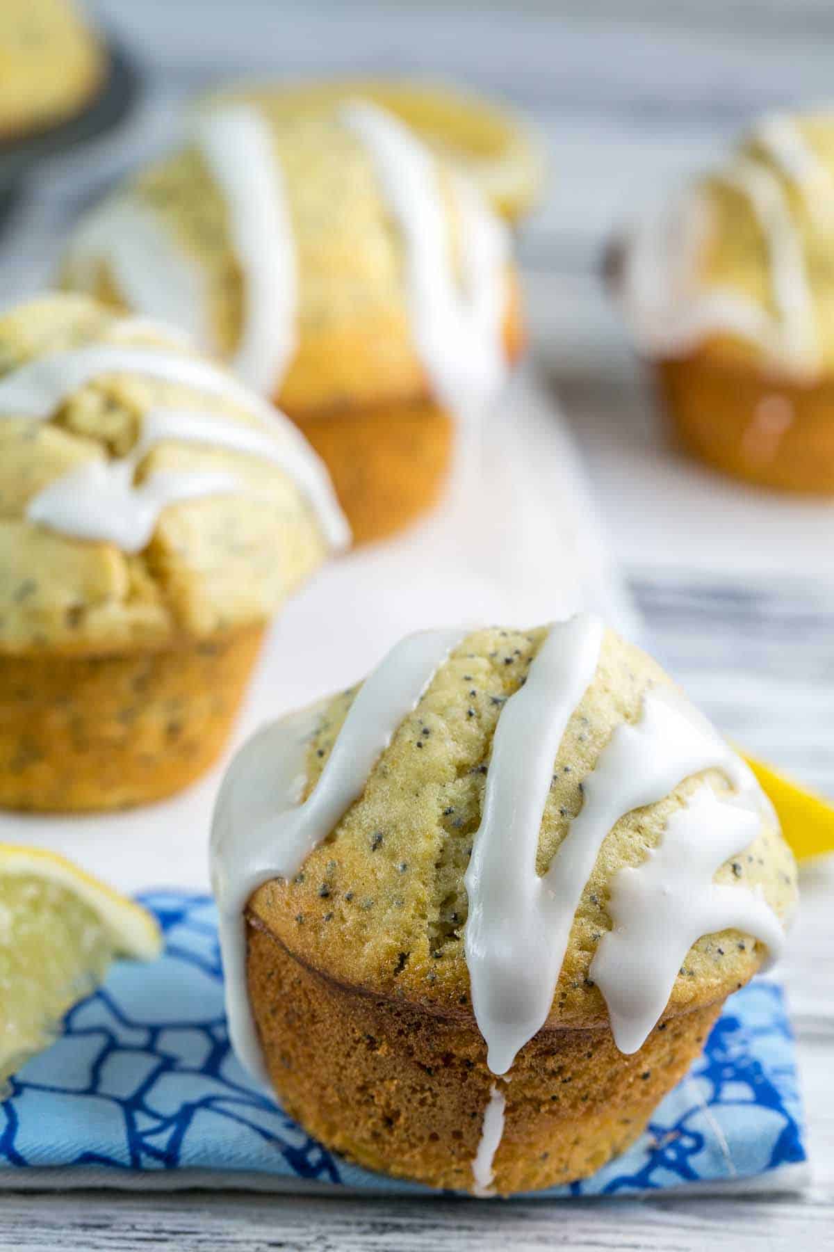 lemon poppy muffins with a thick squiggle of glaze on the top.