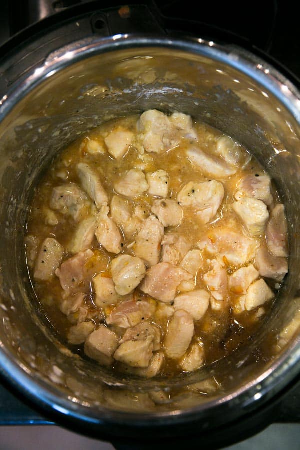 chicken with orange sauce inside an instant pot before cooking