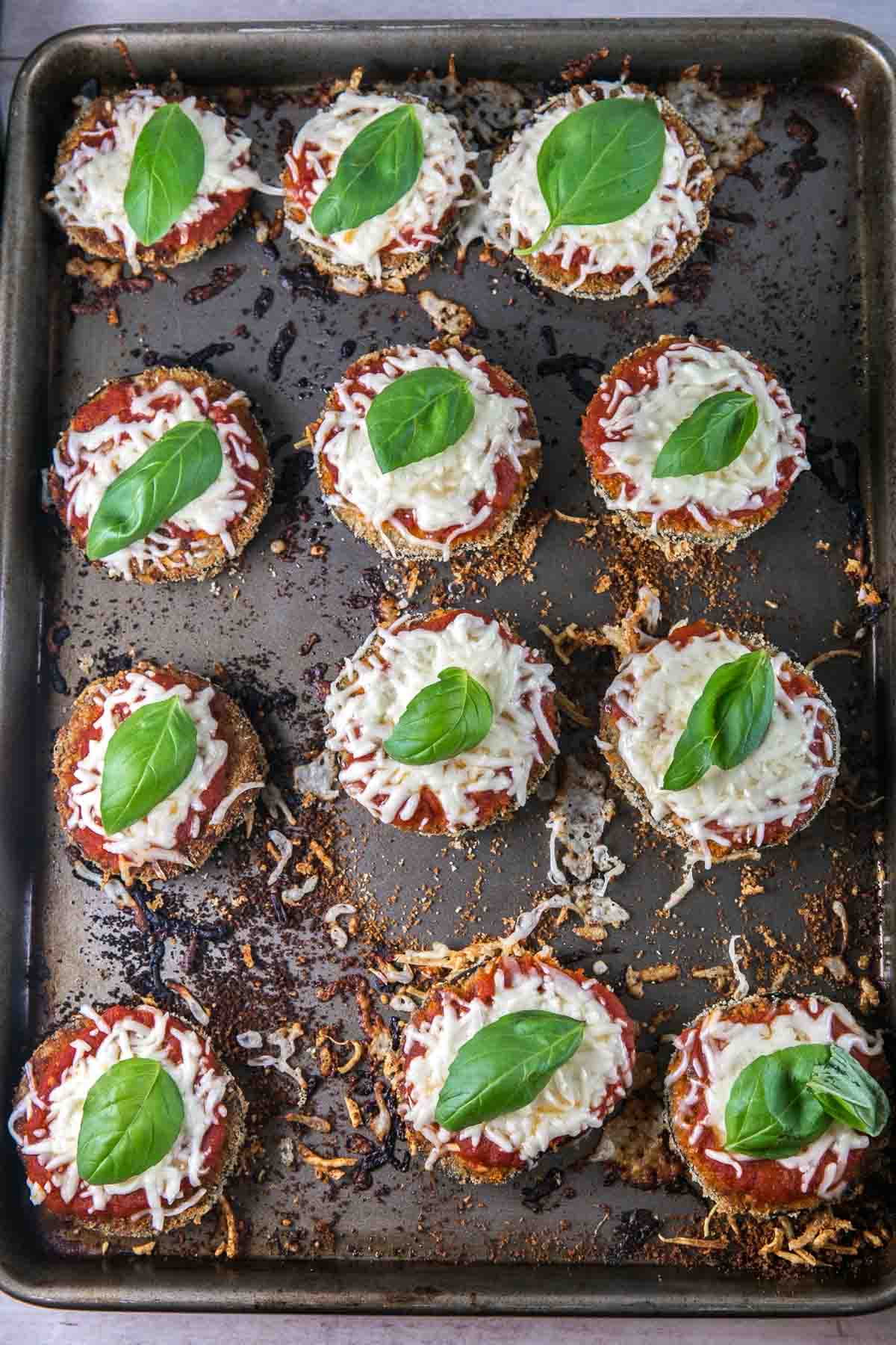 sheet pan filled with stacks of baked eggplant parmesan.