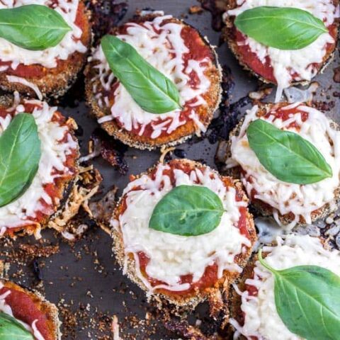 stacks of baked eggplant parmesan on a sheet pan