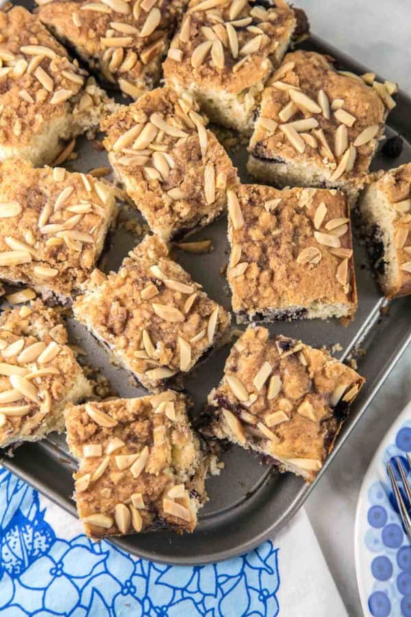 cut squares of blueberry almond breakfast cake sitting on a square springform pan