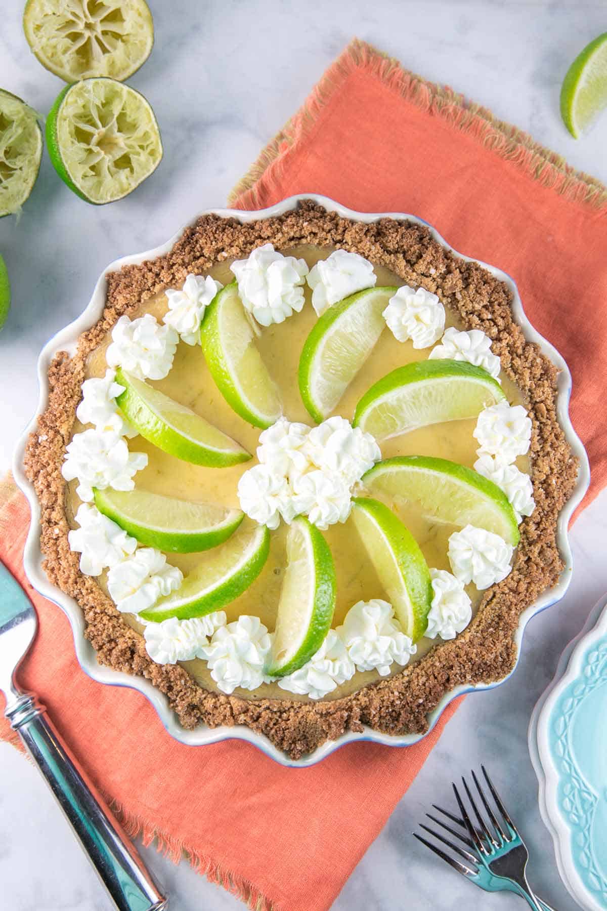 lime custard pie in a graham cracker crust decorated with whipped cream and lime slices