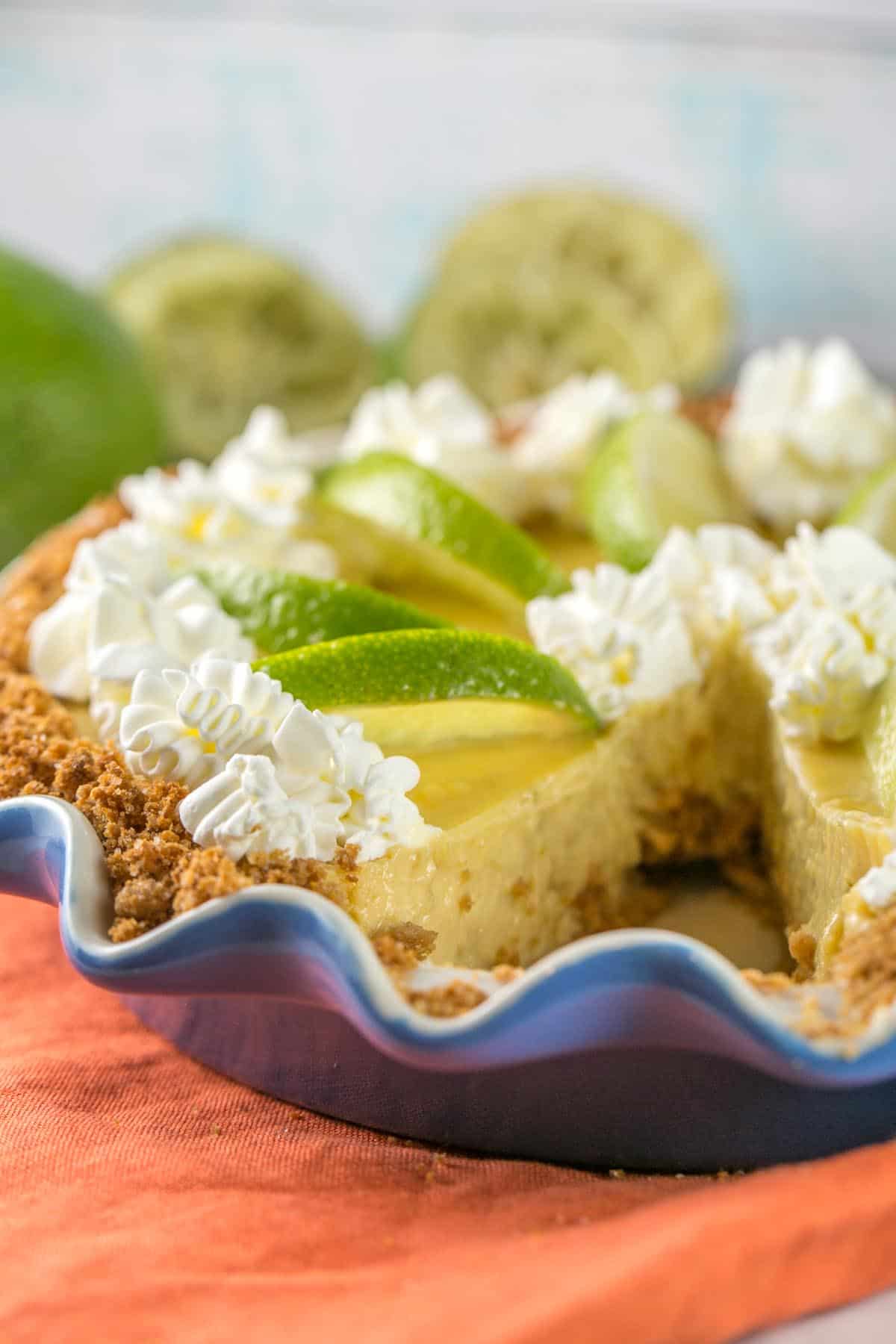 tequila lime margarita pie in a blue pie dish with one slice of pie removed